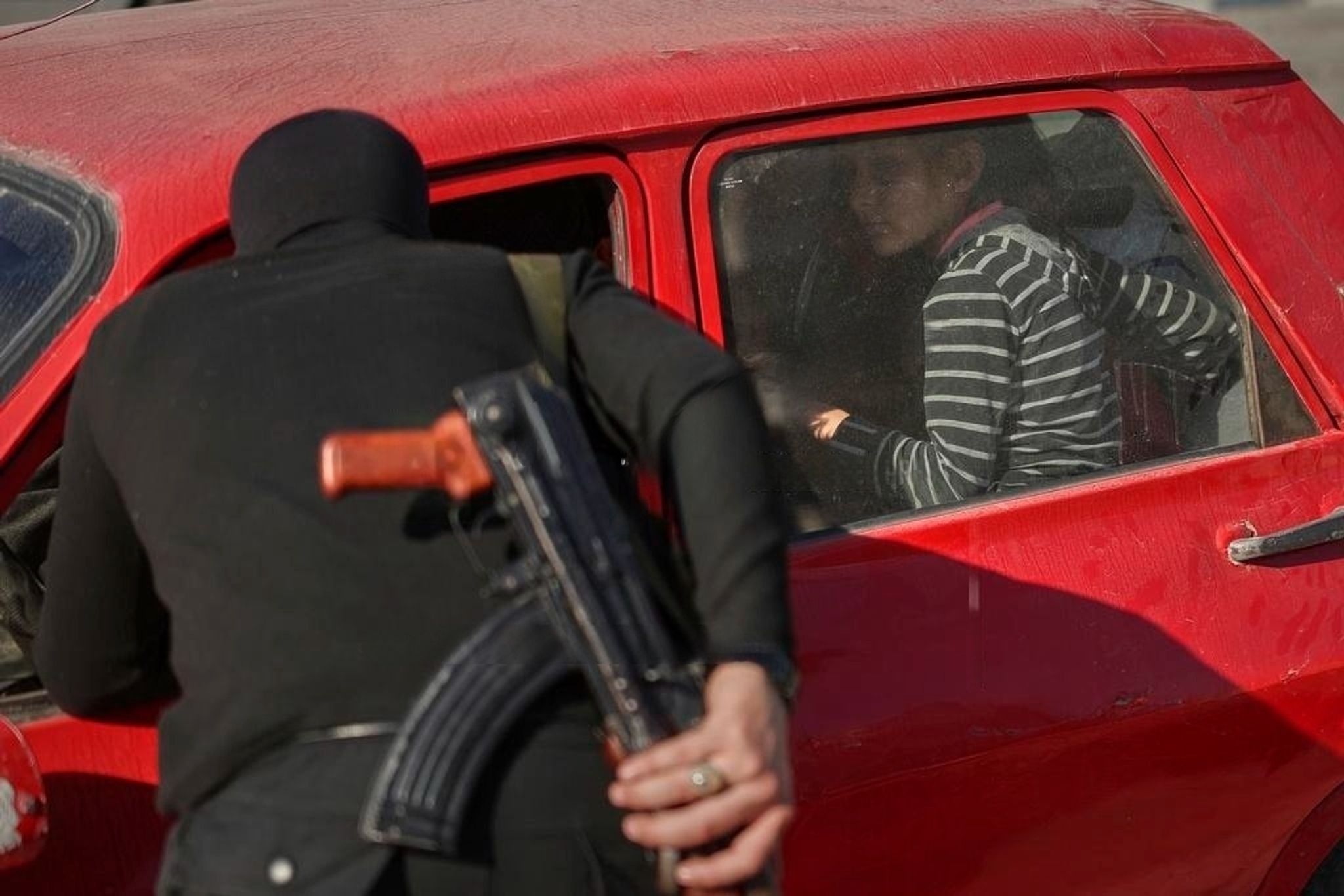 A security officer checks IDs at a checkpoint in Latakia, March 11