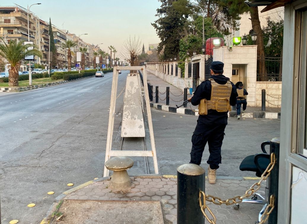 A Syrian security officer guards a checkpoint in Damascus.