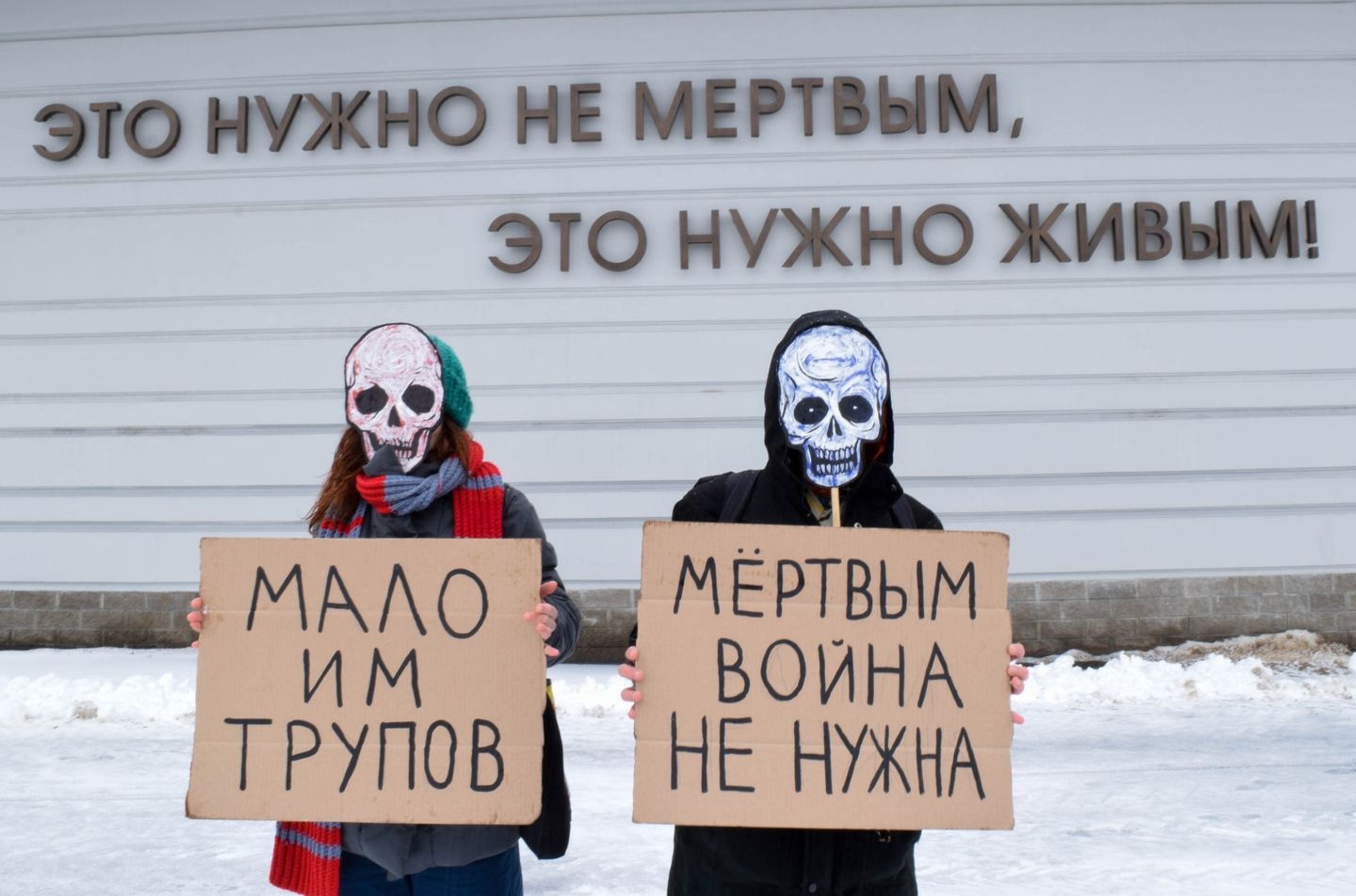 (In the background) "The dead do not need this. The living do." (Signs) "Too few corpses." "The dead don't need war."