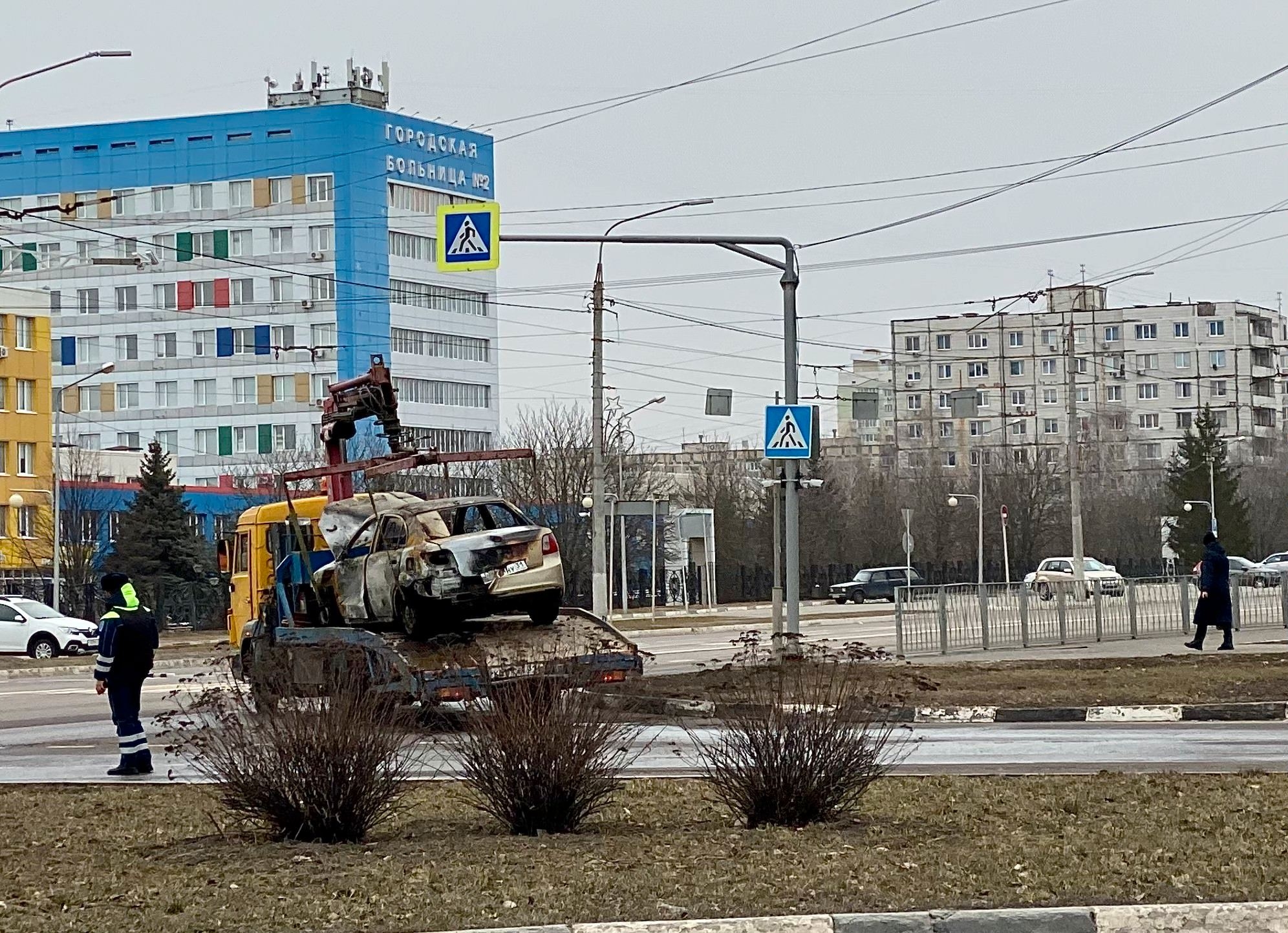Municipal workers haul away cars damaged in the shelling
