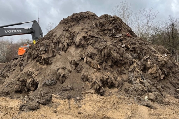 The sand and fuel oil mixture being dumped at a 'temporary storage site' near the village of Voskresensky.