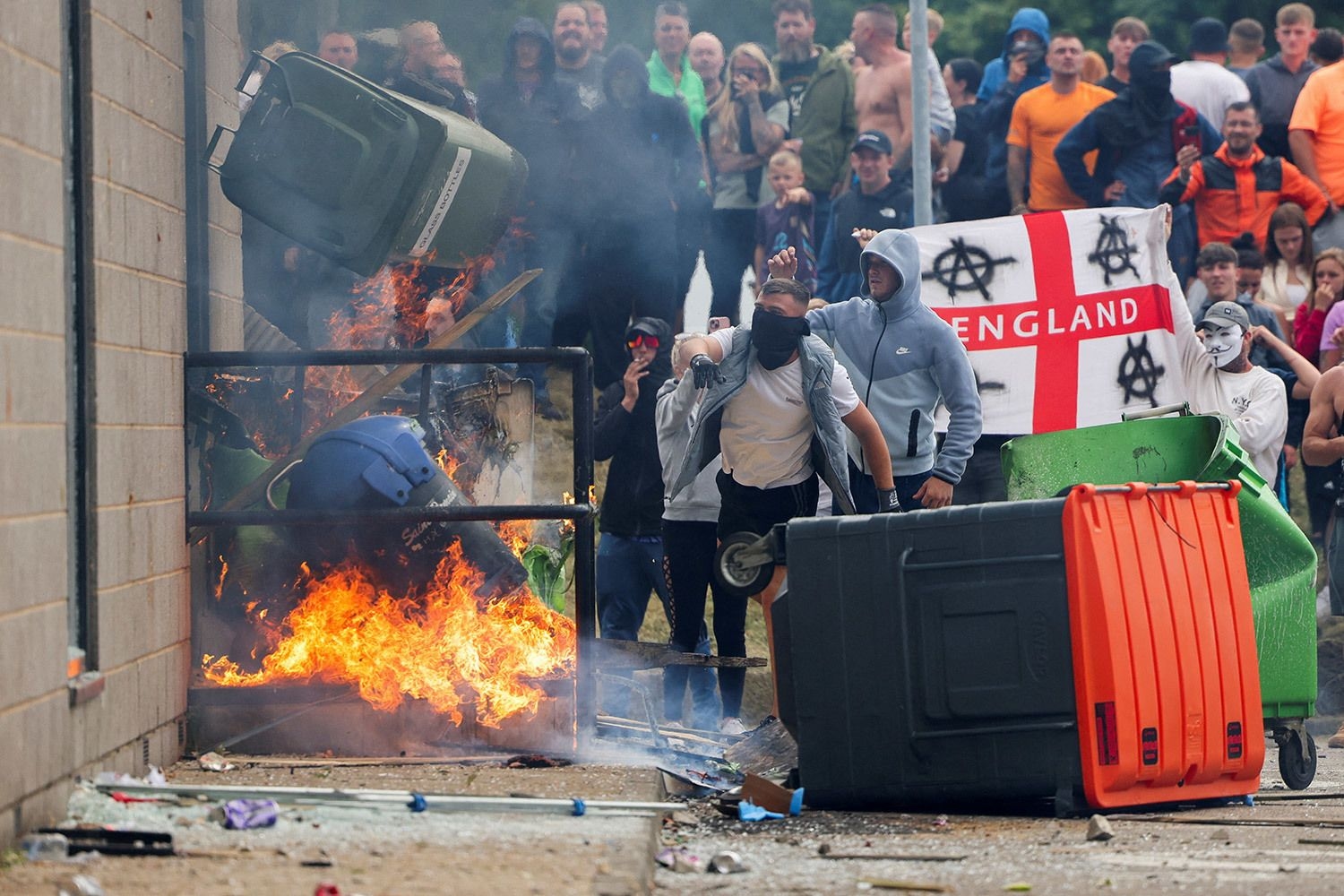 Protesters toss a trash bin during an anti-immigration riot in Rotherham, England, on Aug. 4, 2024.